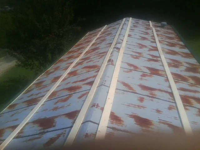 Rusted metal roof panels with new wood purlins before replacement — Storm Damage Roof Repair in Sayre by Roofing Brothers